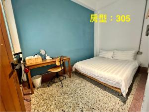 een kleine slaapkamer met een bed en een bureau bij 阡陌-分享民宿 in Tainan