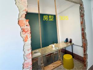 een spiegel in een kamer met een tafel en een kruk bij 阡陌-分享民宿 in Tainan