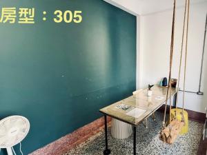 een kamer met een groene muur met een schommel bij 阡陌-分享民宿 in Tainan