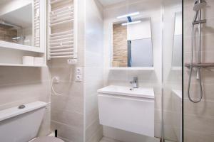 une salle de bains blanche avec toilettes et lavabo dans l'établissement Grand Studio front de mer - Climatiser avec place de parking, à La Celle-sous-Gouzon 26 autres photos