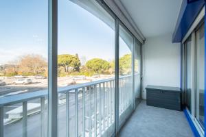 une pièce vide avec un balcon avec de grandes fenêtres dans l'établissement Grand Studio front de mer - Climatiser avec place de parking, à La Celle-sous-Gouzon
