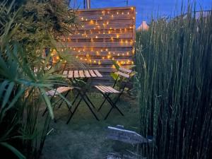a garden with a bench and a fence with lights at Studio au couleur de l’océan in Riantec +20 photos