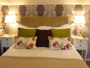 una camera da letto con un letto con due comodini e due lampade di The Saddlery Holiday Cottage - Near Wolds And Coast a North Thoresby