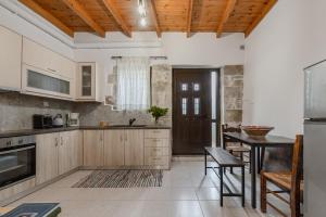 eine Küche mit Holzschränken und einem Tisch in der Unterkunft Kalimera Loft I , Village Experience in Argyroupoli