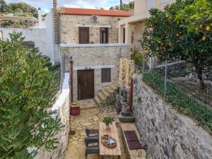 ein kleiner Innenhof mit einem Tisch und einem Orangenbaum in der Unterkunft Kalimera Loft I , Village Experience in Argyroupoli