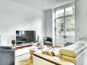 een woonkamer met een bank en een tv bij Au jardin de la Basilique in Boulogne-sur-Mer