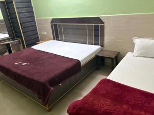 a bedroom with two beds and a bench next to it at Hotel Mohan in Agra +14 photos