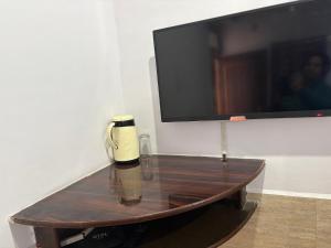 a coffee table with a coffee pot and a flat screen tv at Hotel Mohan in Agra