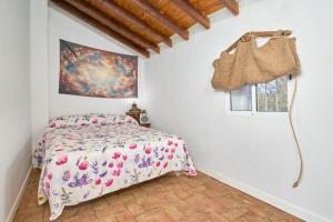 ein Schlafzimmer mit einem Bett und einem Fenster in der Unterkunft Cortijo Palomo in Benamocarra + 36 Fotos
