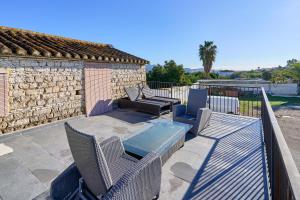 eine Terrasse mit Stühlen und einem Tisch und einem Gebäude in der Unterkunft Cortijo Palomo in Benamocarra