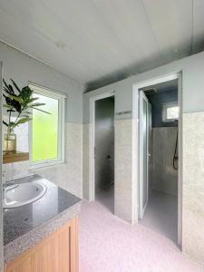 ein Bad mit einem Waschbecken und einer ebenerdigen Dusche in der Unterkunft Chay Lap Farmstay Phong Nha in Ðá Lòn