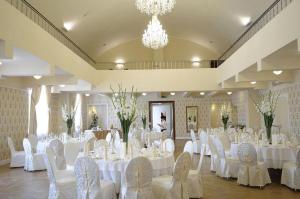 un salón de banquetes con mesas y sillas blancas en Hotel Skala, en Biała Podlaska