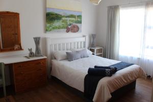 une chambre avec un lit, une commode et une fenêtre dans l'établissement Die Dik Vis, à Velddrif