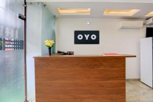 een receptiebalie van een kantoor met het OVO-logo aan de muur bij Hotel O Shad Residency in Patna