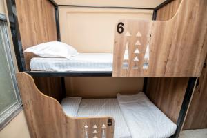 a bunk room with a bed and a chair at Sands Inn Hostel - Diriyah in Riyadh