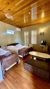 Großes Zimmer mit 3 Betten und einem Tisch in der Unterkunft Garden Sheki Hotel in Şəki + 6 Fotos