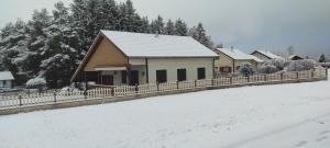 een huis met een hek in de sneeuw bij Location d'un chalet de vacances in Pont-de-Poitte