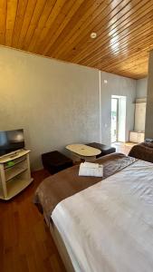 ein Schlafzimmer mit einem großen Bett und einer Holzdecke in der Unterkunft Garden Sheki Hotel in Şəki