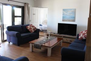 un salon avec deux chaises et une télévision dans l'établissement Die Dik Vis, à Velddrif