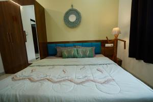 een slaapkamer met een groot bed met een blauw hoofdeinde bij Captain Go-Go 1 bhk apartment in Indore