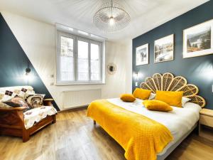 a bedroom with a bed with yellow sheets and a chair at Au Beau Duplex de la Basilique in Boulogne-sur-Mer