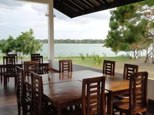 une salle à manger avec des tables et des chaises et une vue sur l'eau dans l'établissement Naaval Hotel, à Batticaloa