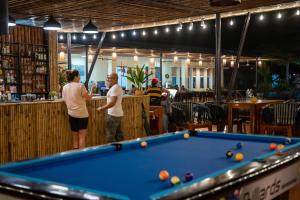 Zwei Personen stehen in einer Bar an einem Billardtisch. in der Unterkunft Chay Lap Farmstay Phong Nha in Ðá Lòn