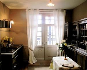 una cocina con ventana y una mesa con flores. en Chambres d'hôtes Le Clos Saint Léonard, en Boersch