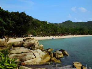 a beach with rocks and people on the beach at Regent Room Hotel in Surat Thani