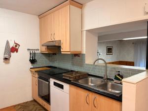 a kitchen with wooden cabinets and a sink at Casa Escalones in Villalba +24 photos