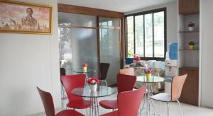 a dining room with two tables and red chairs at Regent Room Hotel in Surat Thani