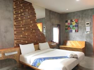 een slaapkamer met een bed en een bakstenen muur bij Tanisa Resort in Na Dhung +198 foto's