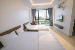ein Hotelzimmer mit zwei Betten und einem Fenster in der Unterkunft Hiếu Thảo Hotel & Restaurant Sầm Sơn in Sầm Sơn