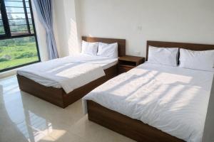 ein Schlafzimmer mit zwei Betten und einem Fenster in der Unterkunft Hiếu Thảo Hotel & Restaurant Sầm Sơn in Sầm Sơn + 45 Fotos