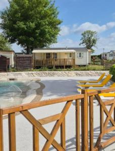 une piscine avec des chaises et une maison en arrière-plan dans l'établissement Mobil-home camping Le Ptit Rio, à Noyelles-sur-Mer