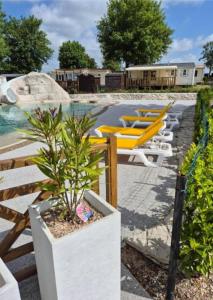 une piscine avec plein de chaises et une plante dans l'établissement Mobil-home camping Le Ptit Rio, à Noyelles-sur-Mer 2 autres photos