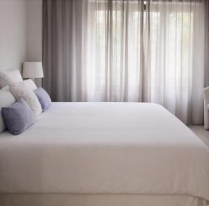 ein großes weißes Bett in einem Schlafzimmer mit weißen Vorhängen in der Unterkunft MEDITERRANEAN SEASONS, VILLA MEDITERRANEA Taormina, Private Pool & Sea View in Taormina