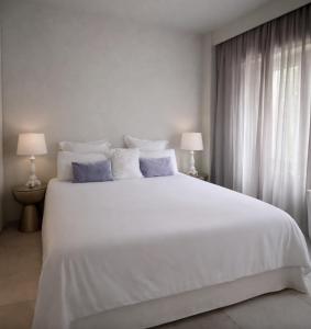 ein Schlafzimmer mit einem großen weißen Bett mit zwei Lampen in der Unterkunft MEDITERRANEAN SEASONS, VILLA MEDITERRANEA Taormina, Private Pool & Sea View in Taormina