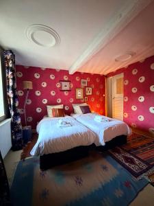 ein Schlafzimmer mit einem großen Bett mit roten Wänden in der Unterkunft Gite des 2 églises in Tieffenbach