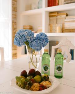 a table with a plate of food and a vase with flowers at A galería do san Ramón in Villalba