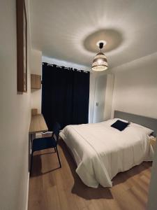 a bedroom with a bed and a table and a chair at Maison et chambre privée - Bordeaux in Bordeaux +12 photos