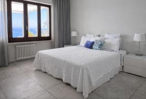 ein weißes Schlafzimmer mit einem Bett und einem Fenster in der Unterkunft MEDITERRANEAN SEASONS, VILLA MEDITERRANEA Taormina, Private Pool & Sea View in Taormina