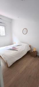 ein Schlafzimmer mit einem Bett und einer Uhr an der Wand in der Unterkunft Magnifique duplex T3 in Breil-sur-Roya