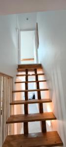 eine Holztreppe in einem Zimmer mit Fenster in der Unterkunft Magnifique duplex T3 in Breil-sur-Roya