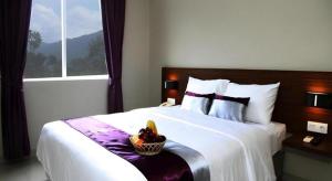 een slaapkamer met een bed met een schaal fruit erop bij Amantis Hotel in Demak +53 foto's