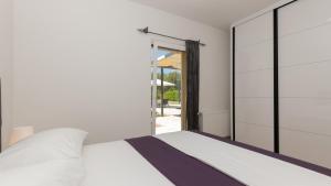 ein Schlafzimmer mit einem weißen Bett und einer Glasschiebetür in der Unterkunft Villa Tea - Makarska by Villas Guide in Gornji Vinjani + 37 Fotos