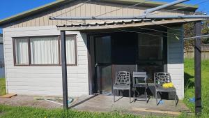 een huis met twee stoelen en een tafel op een terras bij Bayfair Backpack House in Tauranga