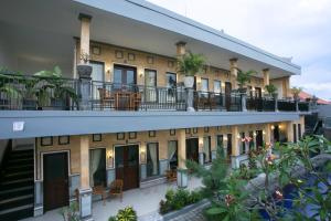 anterior view of a building with balconies and plants at Wijaya Guesthouse in Canggu