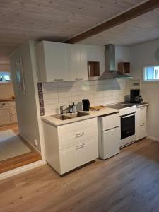 een keuken met witte kasten en een spoelbak bij Hus in Orkelljunga