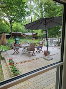 een terras met een tafel, stoelen en een parasol bij Hus in Orkelljunga